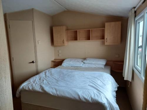 a small bedroom with two beds and a window at 6 Berth The Chase Ingoldmells (The Rio) in Ingoldmells