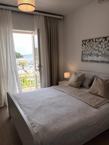 a bedroom with a large bed with a large window at Apartment & Rooms Riva in Vodice