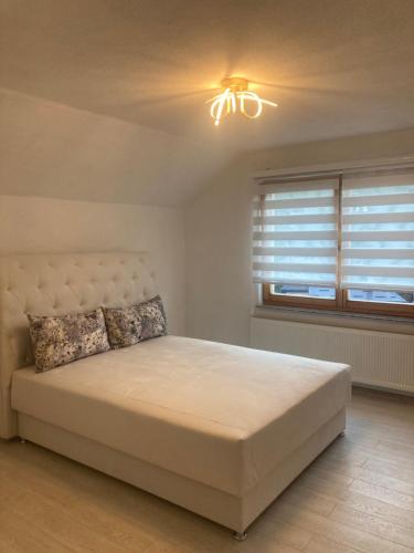 a bedroom with a large bed and a window at Apartman SARA in Sarajevo