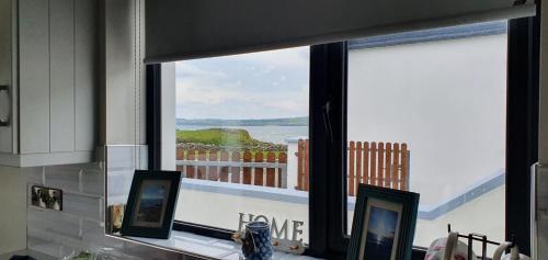 a room with a window with a view of the ocean at Beside the sea & minutes from Cliffs-Clahane Shore Lodge in Liscannor