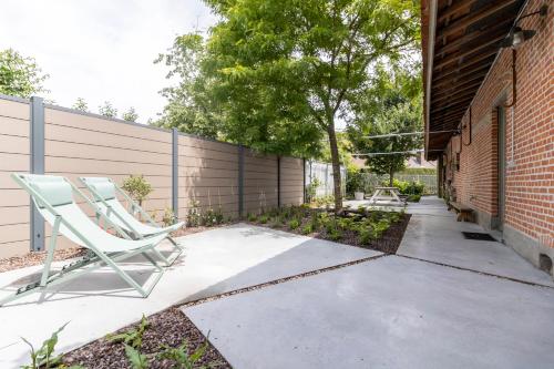 une chaise assise sur un trottoir à côté d'une clôture dans l'établissement KROOST, à Lokeren