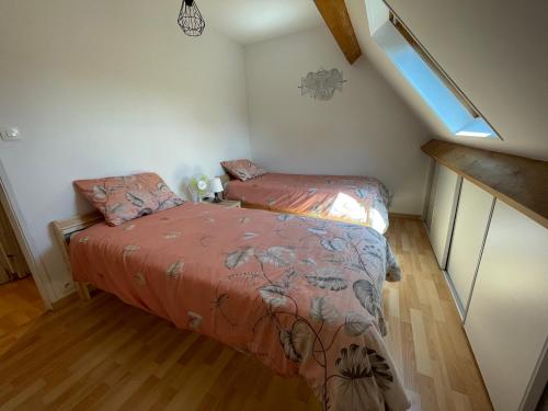 a bedroom with two beds in a attic at Gîte à la campagne mais proche de tout in Moringhem