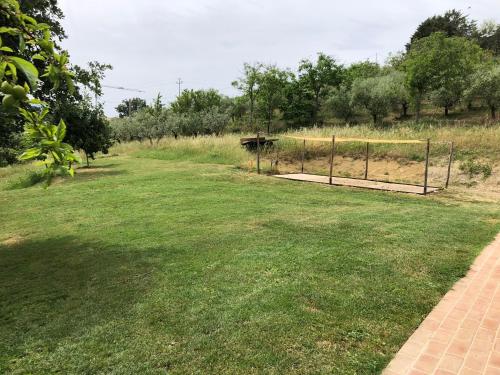 un campo de hierba con una valla y un objetivo en Agriturismo Sant'Angelo holiday farm, en Gualdo Cattaneo
