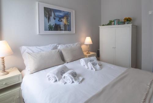 a bedroom with a white bed with towels on it at Casa da Travessa - Óbidos in Óbidos