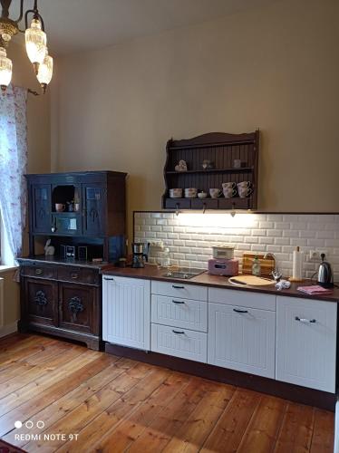 eine Küche mit weißen Schränken und einer Arbeitsplatte in der Unterkunft Herrenhaus Harmshagen in Testorf-Steinfort
