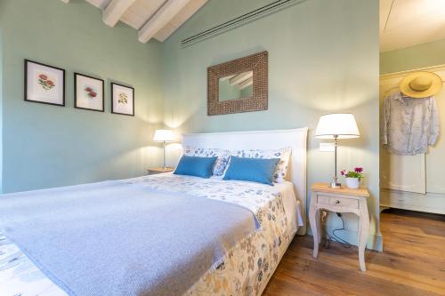 a bedroom with a large bed with blue pillows at Isola Bella Apartments Via Stretta in Stresa
