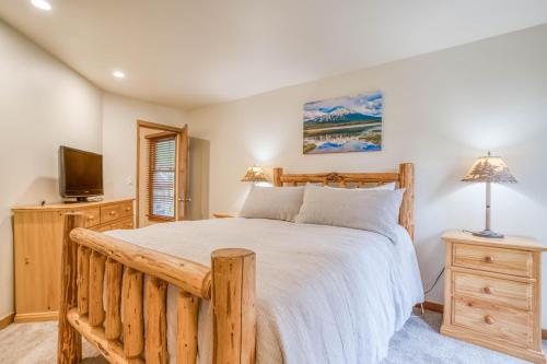 um quarto com uma cama de madeira e uma televisão em Ski House 155 em Bend