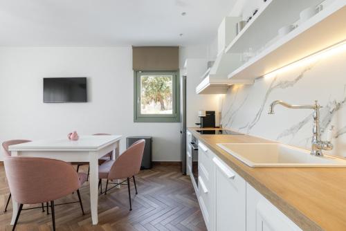 a kitchen with a table and chairs and a sink at Helia All Seasons Apartments in Astris