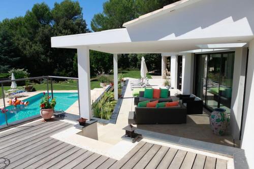 une terrasse avec une piscine et une maison dans l'établissement Luxurious villa 4 bedrooms in secluded area, swimming pool, à Valbonne