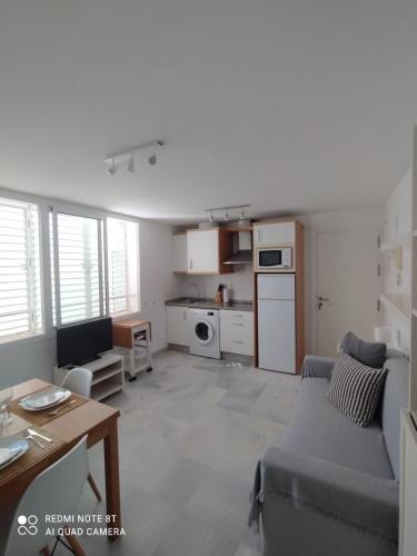 salon z kanapą i kuchnią w obiekcie Ático-Duplex Las Palmeras w mieście Conil de la Frontera