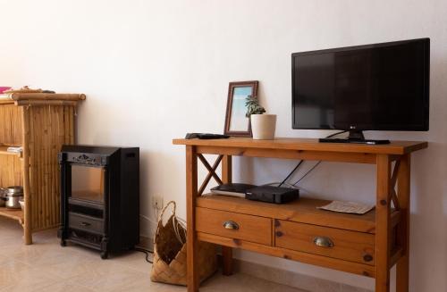 a television on a wooden stand next to a tvictericterictericterictericter at Casa Lusco Fusco in Carrapateira
