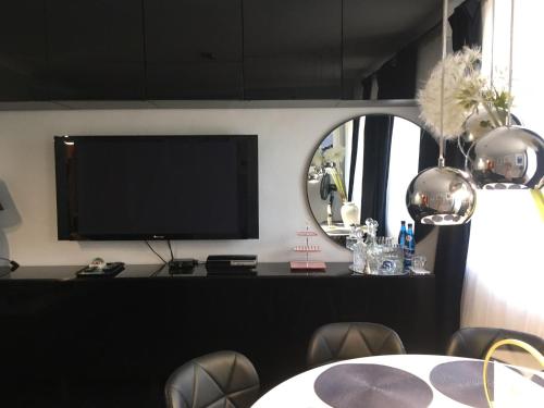 Cette chambre dispose d'une télévision, d'une table et d'un miroir. dans l'établissement Warszawska Apartament Rajgród, à Rajgród