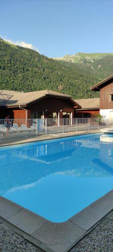 une grande piscine devant un immeuble dans l'établissement DOMAINE DU GRAND TETRAS SAMOENS, à Samoëns