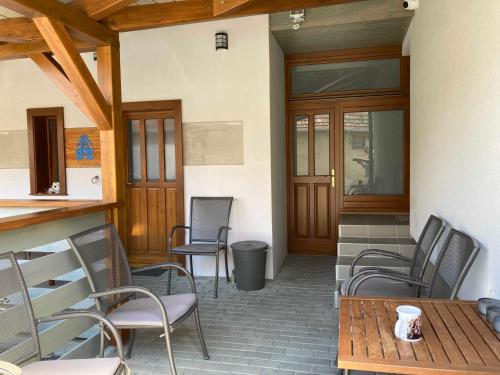d'une terrasse avec des chaises, une table et une porte. dans l'établissement Toronyi Vendégház, à Torony