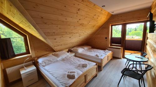 a bedroom with two beds in a wooden cabin at Drewniana chata in Cisówek