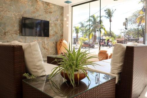 - un salon avec une table et une plante dans l'établissement Pousada Areia Branca, à Arraial do Cabo