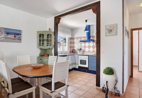 una cucina con un tavolo di legno e una sala da pranzo di Villa Ébano a Conil de la Frontera