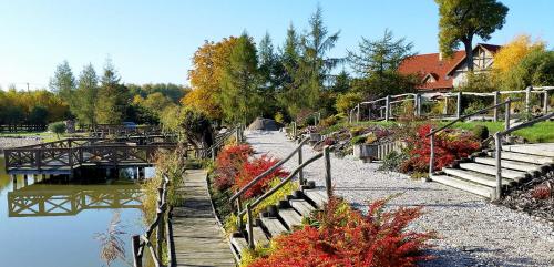 a bridge over a body of water with flowers at Dom Uzdrowisko in Tolkmicko