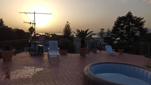 a patio with chairs and a hot tub at sunset at La Terrazza Quisisana Sorrento Coast in Castellammare di Stabia