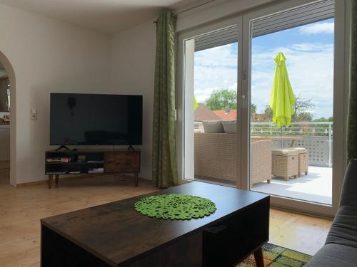 a living room with a television and a large sliding glass door at Schwarzwaldmarie in Bühl