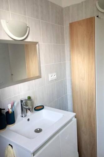 une salle de bain avec un lavabo blanc et un miroir dans l'établissement L'Oustaou, à La Seyne-sur-Mer