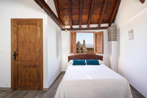 a bedroom with a bed and a wooden door at LM Casa ALBAYCIN in Granada