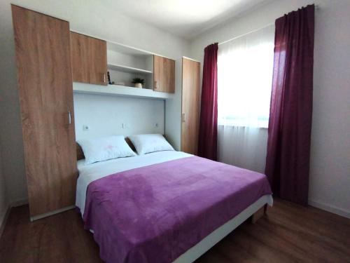 a bedroom with a large bed and a window at Apartman, studio and room Kata in Pula