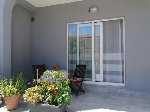 a patio with two chairs and a table and some plants at Apartman, studio and room Kata in Pula