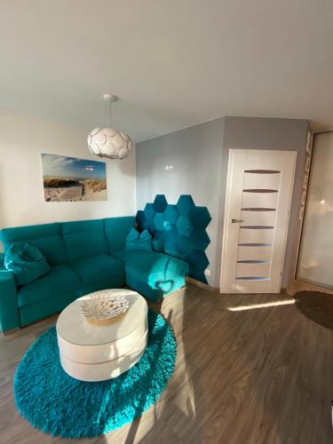 sala de estar con sofá azul y mesa en Luxury Blue Porta Mare, en Dziwnówek