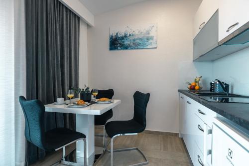 a small kitchen with a white table and chairs at Apartments Niko in Makarska