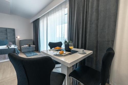 a living room with a table and chairs and a bedroom at Apartments Niko in Makarska