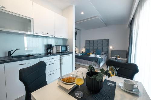 a kitchen and living room with a table and a room with a bed at Apartments Niko in Makarska