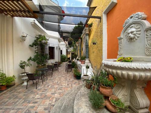 un patio extérieur avec une fontaine, des tables et des chaises dans l'établissement Indian Palace Hotel Boutique Spa & Restaurante, à Antigua Guatemala