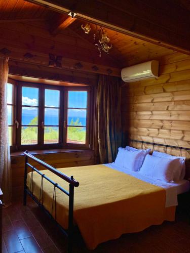 a bedroom with a bed with a view of the ocean at Vigla ias 2 in Paradisos