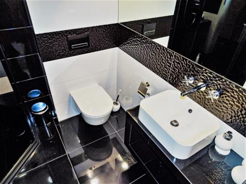 a bathroom with a white sink and a toilet at Apartament Cieplicka in Jelenia Góra