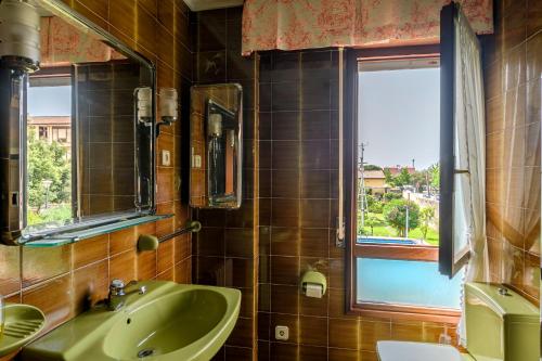 a bathroom with a green sink and a window at Casa marinera con piscina y jardín. in Colindres