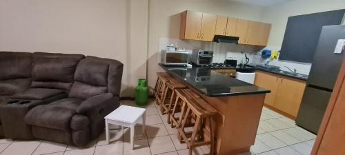 a kitchen with a couch and a chair and a counter at SEASCAPE MEWS 27 in Cape Town
