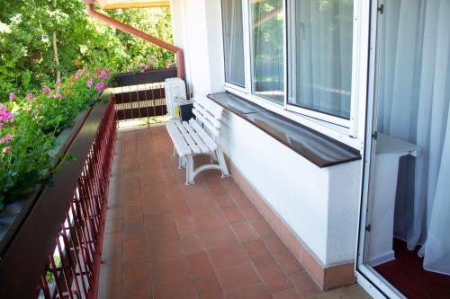 a porch with a bench and a window and flowers at Elita Hotel & Restauracja in Iwonicz-Zdrój