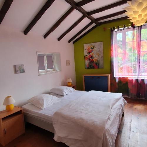 une chambre avec un lit blanc dans une pièce dans l'établissement Les Bambous, à Sauveterre-la-Lémance