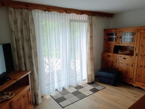 a room with a large window with white curtains at Ferienwohnung Lemberger in Dellach im Drautal