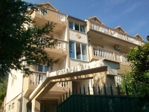 a large building with a fence in front of it at B&B Guest House Vasiljevic in Herceg-Novi