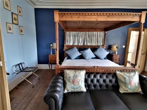 1 dormitorio con 1 cama grande y 1 sofá de cuero en Chateau de Linard, en Linard