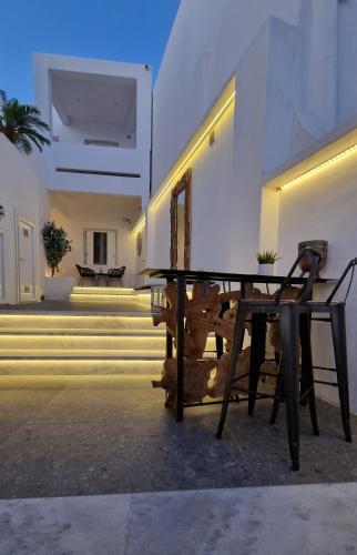 a wooden table in front of a building with stairs at Mykonos Double Luxury Mini Suites-With External Hot spa Adults only in Ano Mera