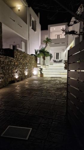 a stone courtyard with a stone wall and buildings at night at Mykonos Double Luxury Mini Suites-With External Hot spa Adults only in Ano Mera