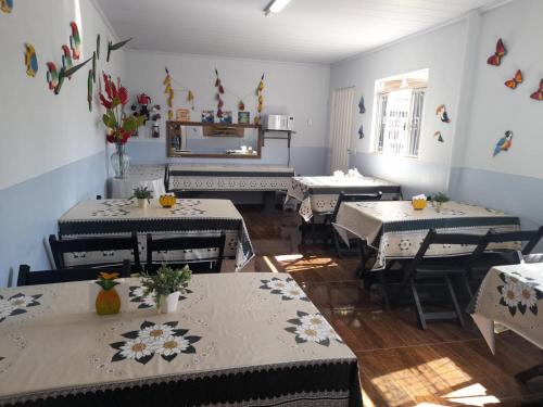 a restaurant with tables and chairs with flowers on them at Hotel 3 irmaos in Três Marias