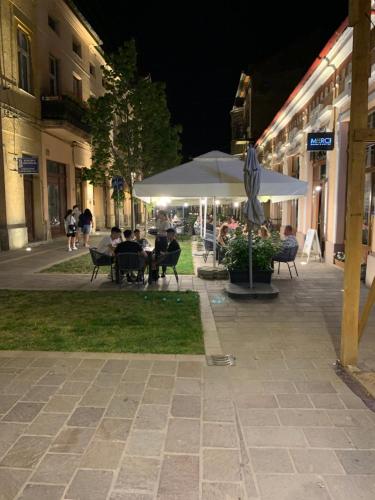 a group of people sitting at tables under an umbrella at Casa Central Luxury in Oradea