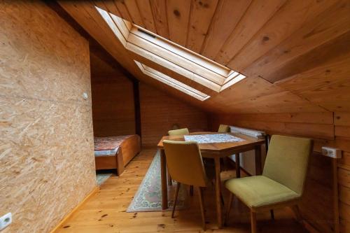 a room with a table and chairs and a skylight at Pokoje nad Szeszupą Jasionkove DOBRO in Rutka Tartak