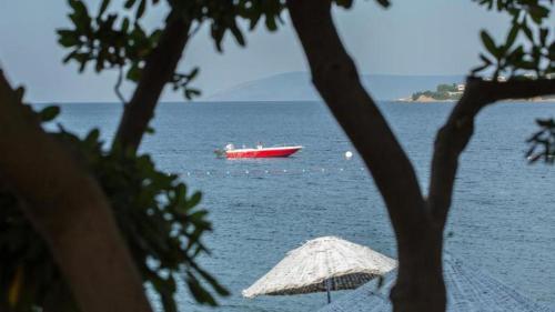 a boat in the water with a red boat in the ocean at Teos Ormanci Tatil Koyu in Seferihisar