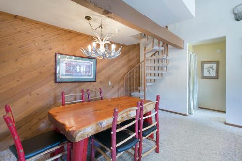 a dining room with a wooden table and a staircase at Aspen Creek by 101 Great Escapes in Mammoth Lakes