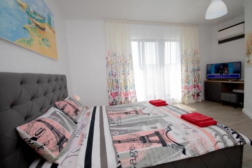 a bedroom with a large bed and a television at Pensiunea Ionelia in Orşova